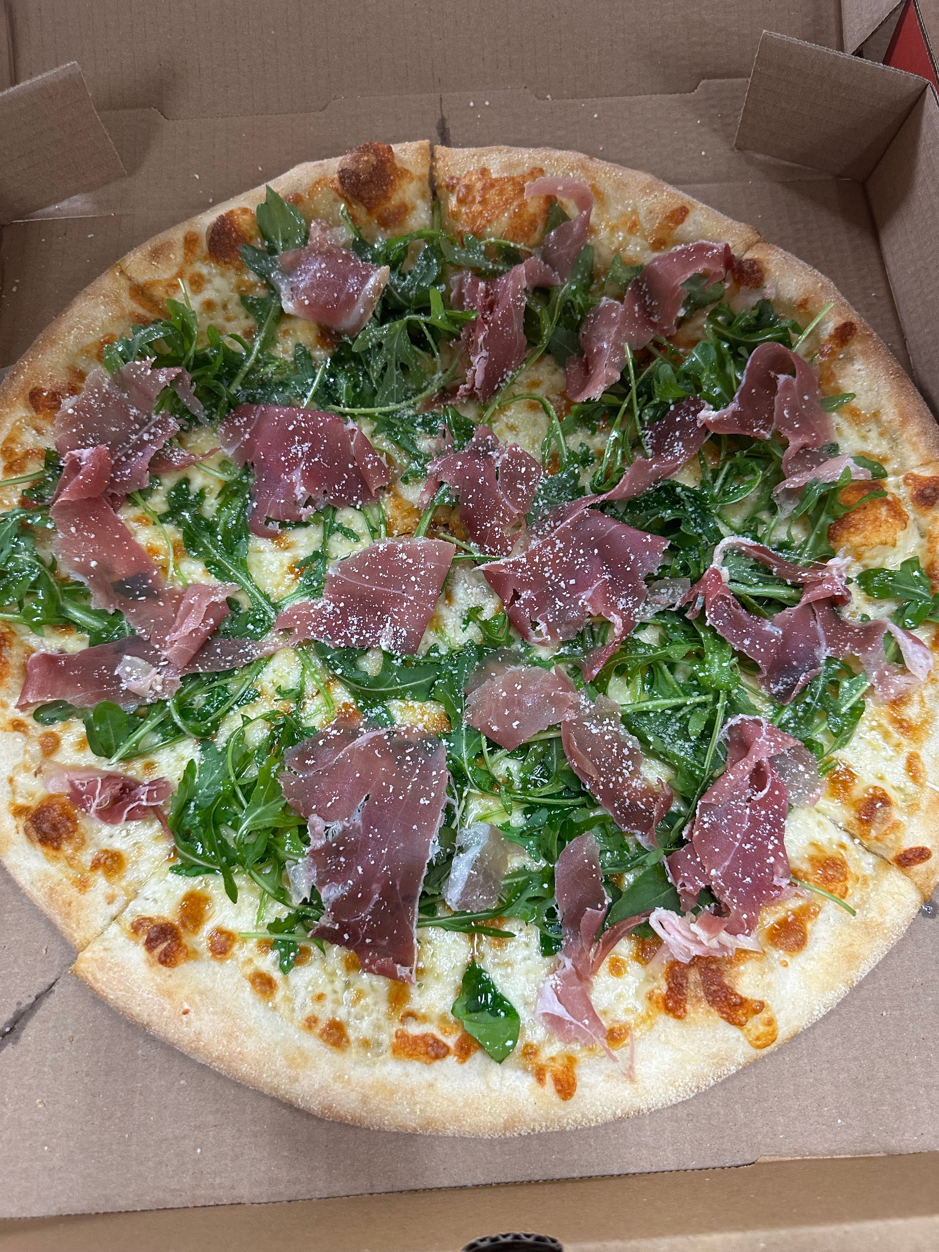 NY Style White Pizza - Topped with Arugula and Prosciutto.