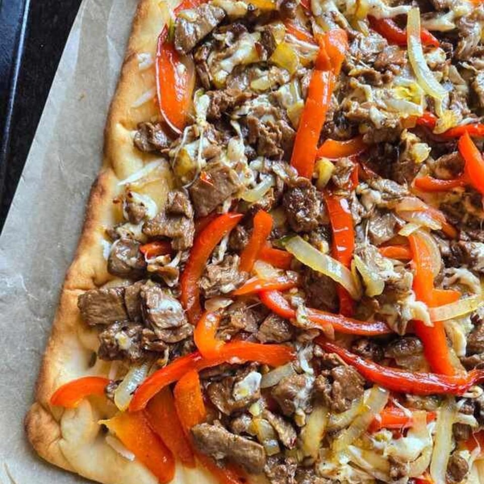 That's Italian Pizza & Pasta's rectangular pizza topped with steak, red peppers, and onions.